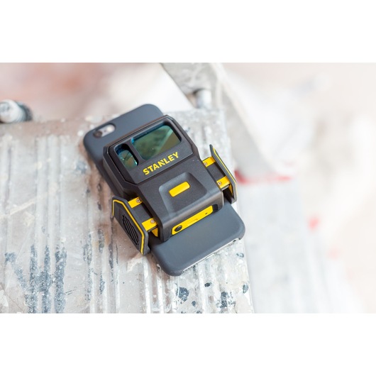 STANLEY STHT1-77366 black and yellow laser distance measurer with phone cradle, close-up side angle.
