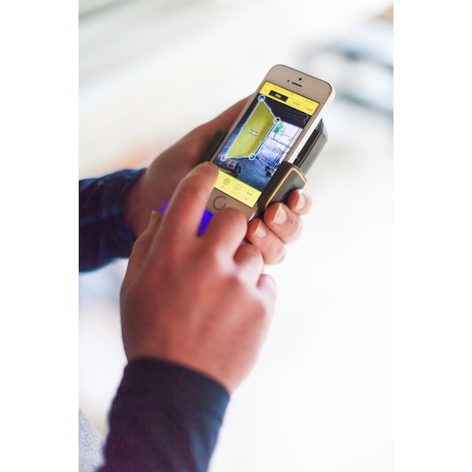 STANLEY STHT1-77366 photography of a hand using laser measure app on smartphone with holder.