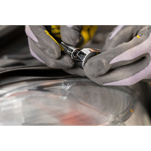 STANLEY STMT82663-0 ratchet being used with gloves near a car headlight, close-up photography.